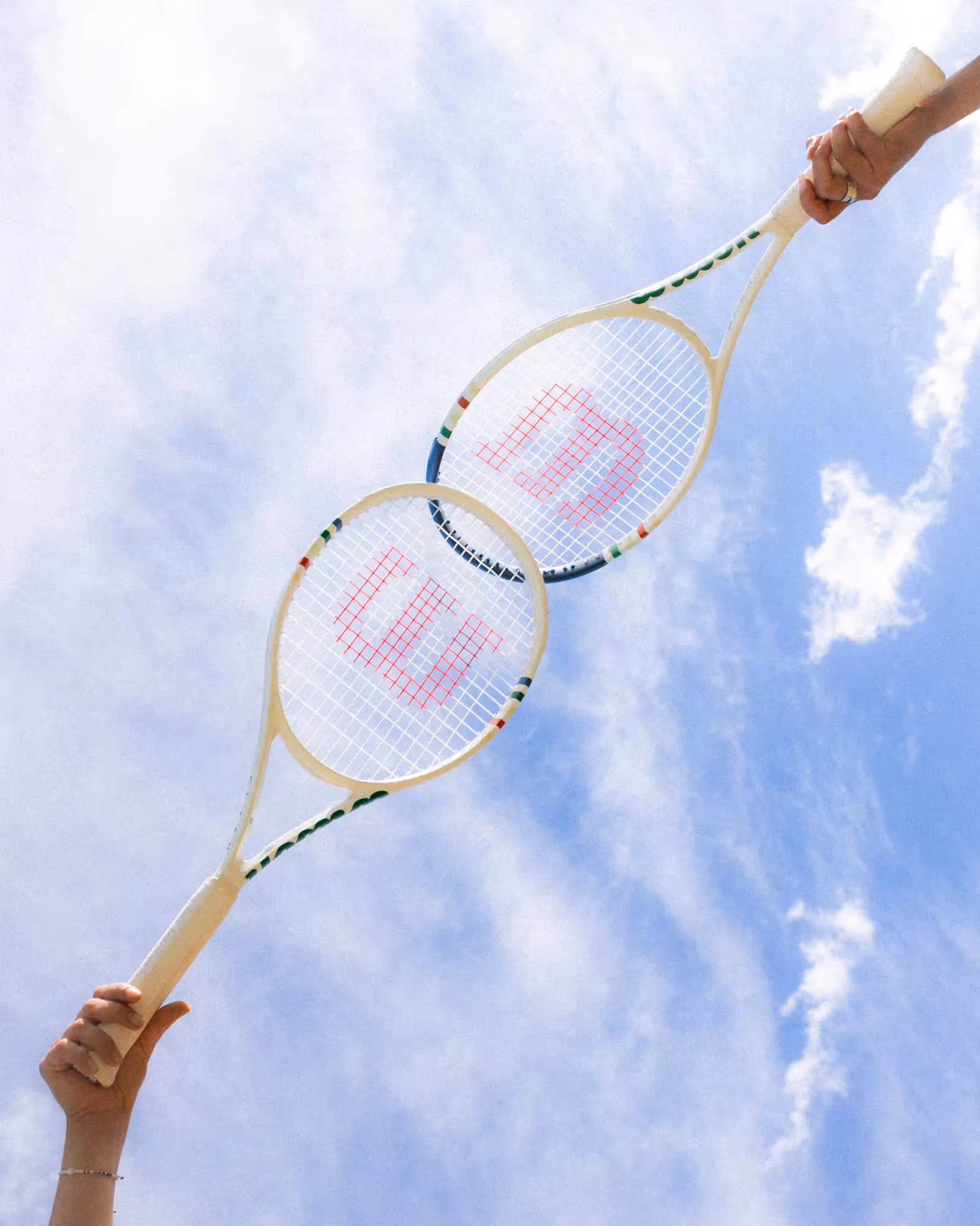 two Wilson tennis racquets against a blue sky