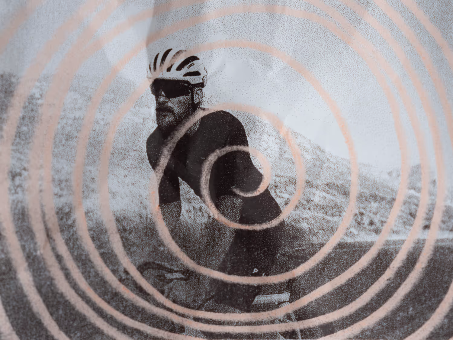 Man on a bike in black and white with a hand drawn pink spiral on top 