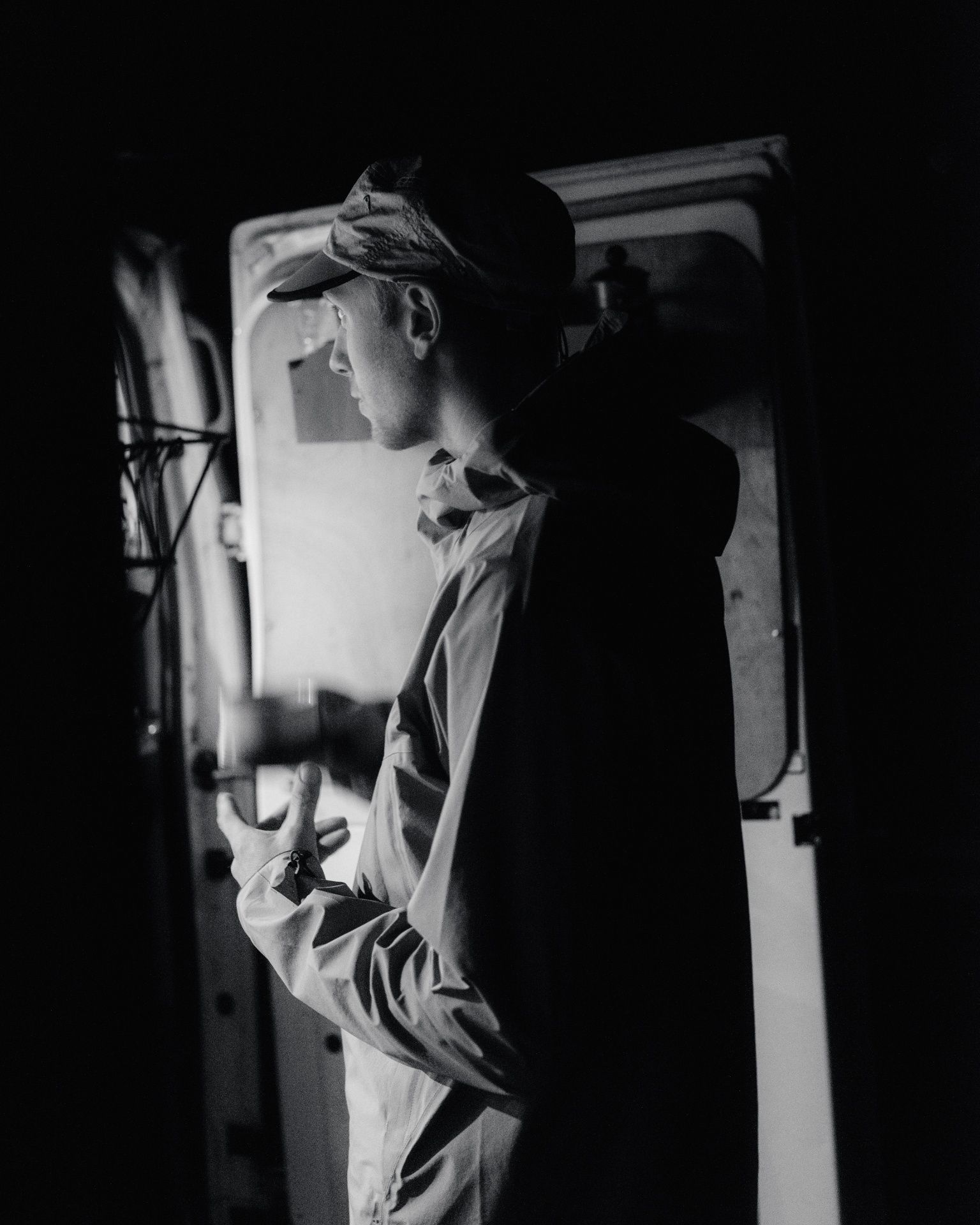 black and white portrait of man looking inside van