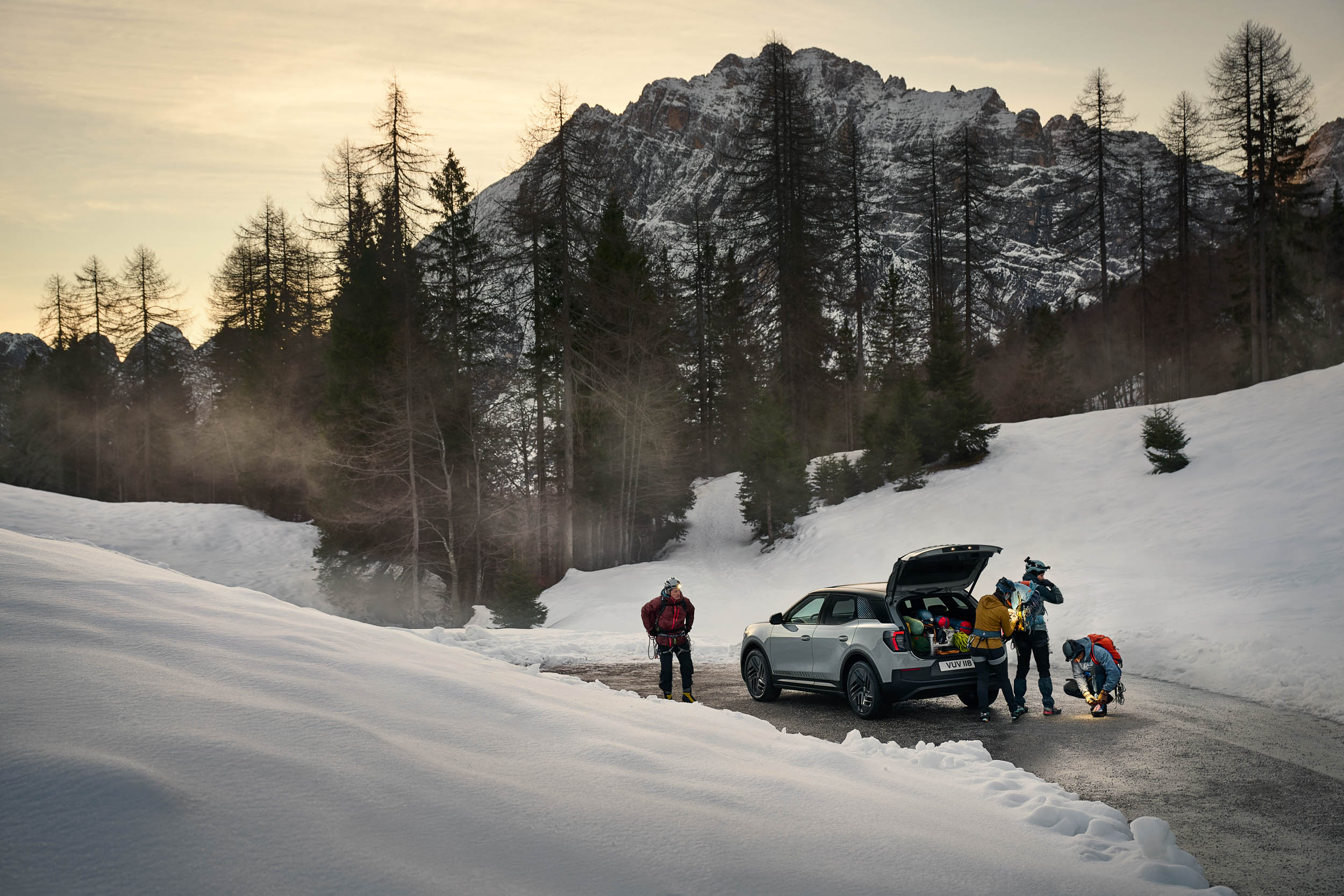 People stood around a car in the mountains