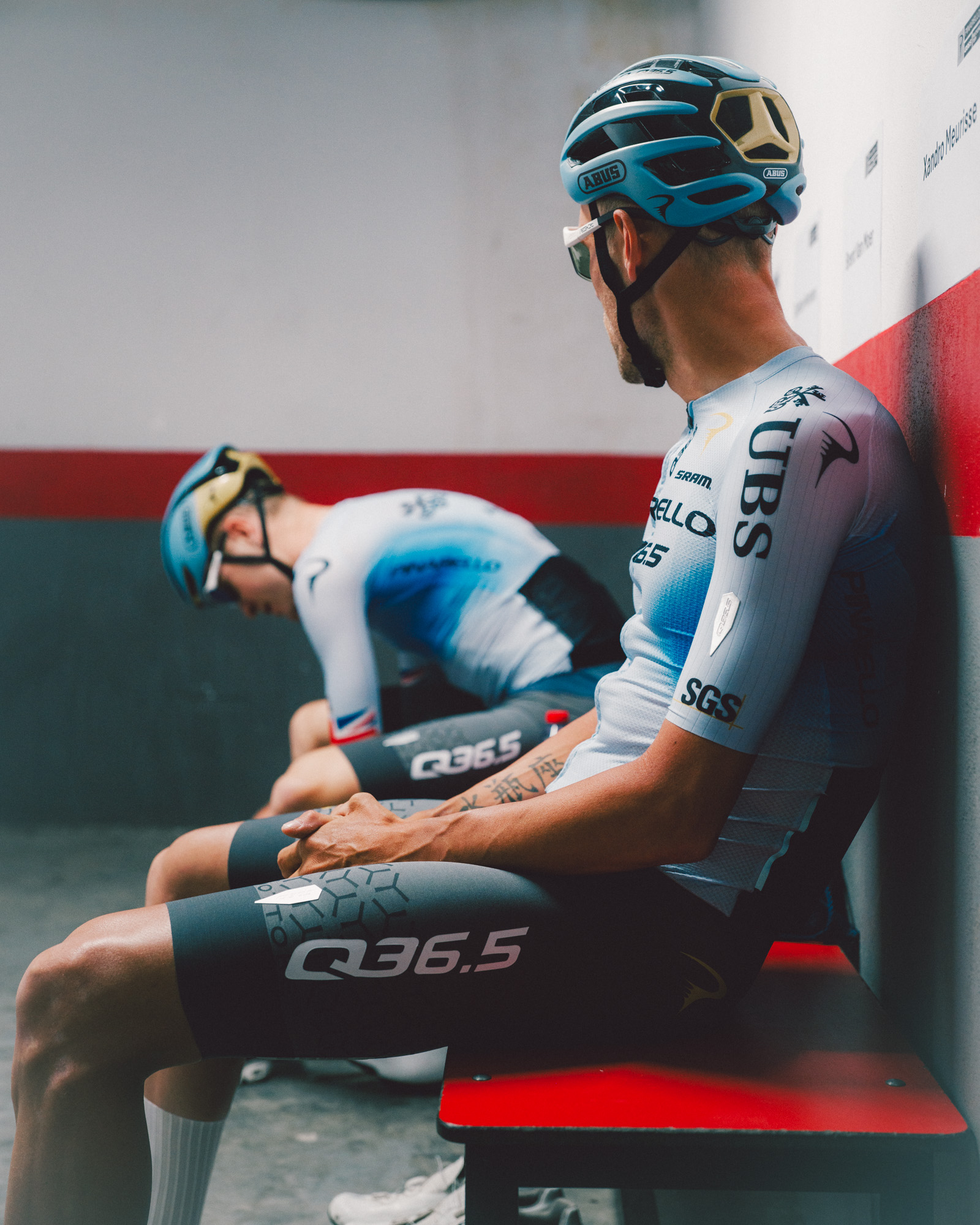 Two cyclists sat on bench