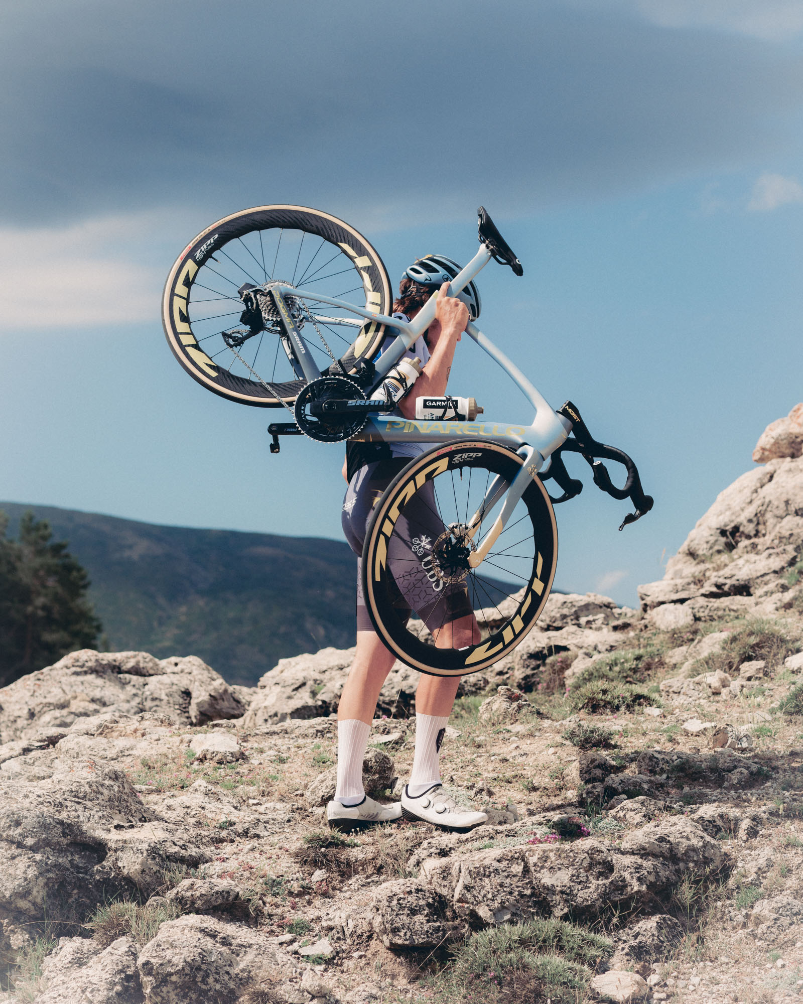 Man carrying bike on rocky mountain