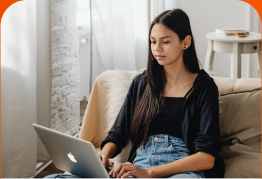 Woman on a sofa using her report on a laptop