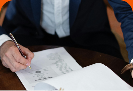 A hand signing a lease document