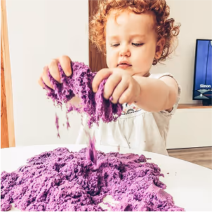 Toddler playing with Kinetic Sand, a Spin Master toy