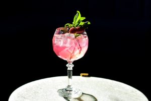 Saturday special hendrick’s gin punch in a balloon glass with gin, Hendricks, Prosecco and raspberry