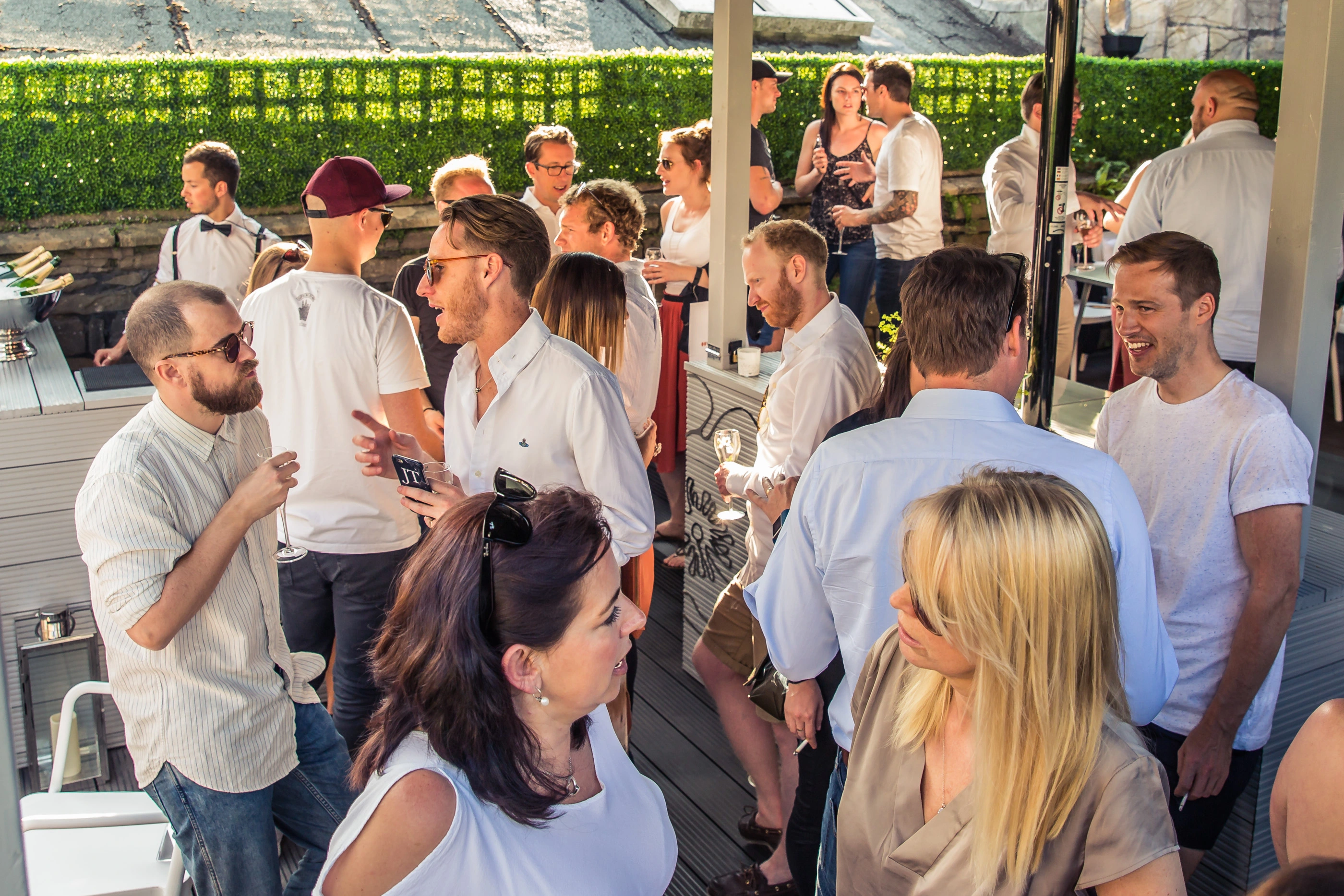 Young professionals mixing and networking at outdoor cocktail terrace Bath
