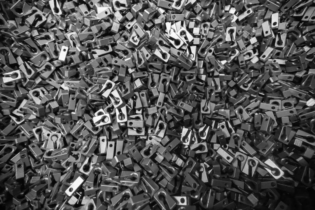 Pile of small metal components stacked together in a bin.