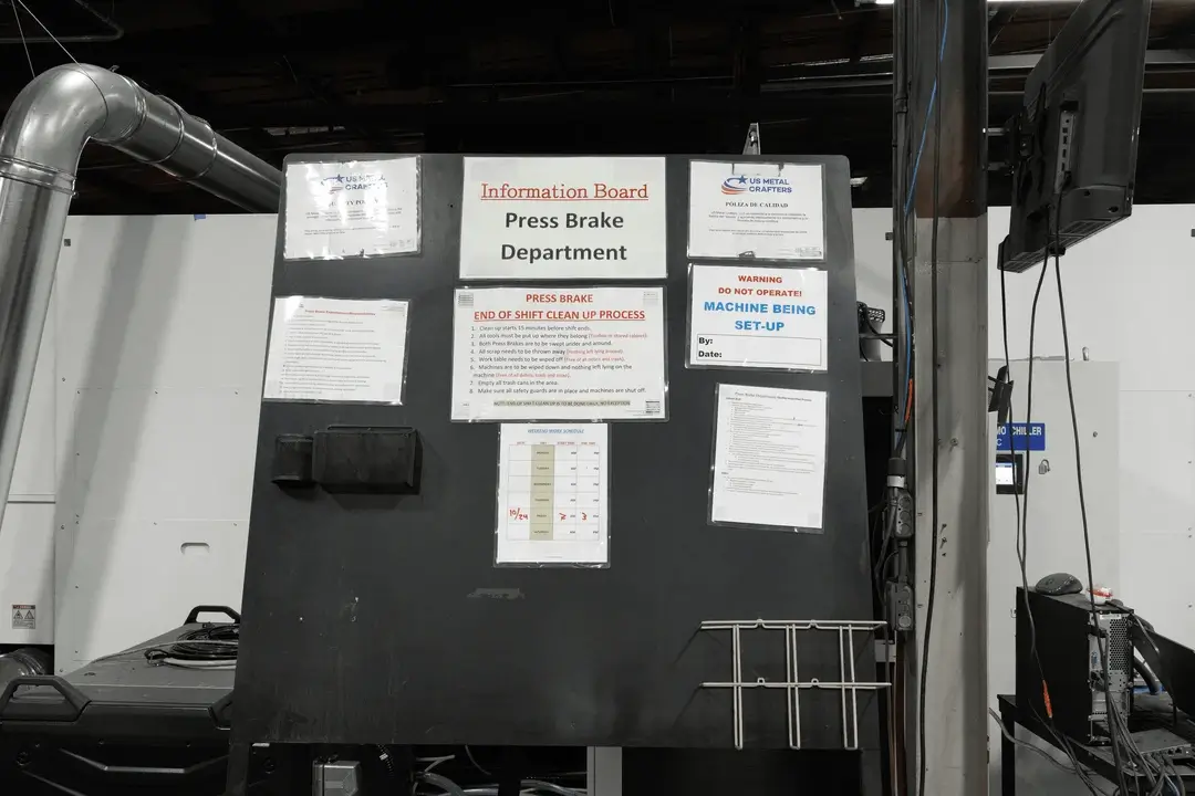 Information board for the Press Brake Department with posted procedures and a “Machine Being Set-Up” warning sign.