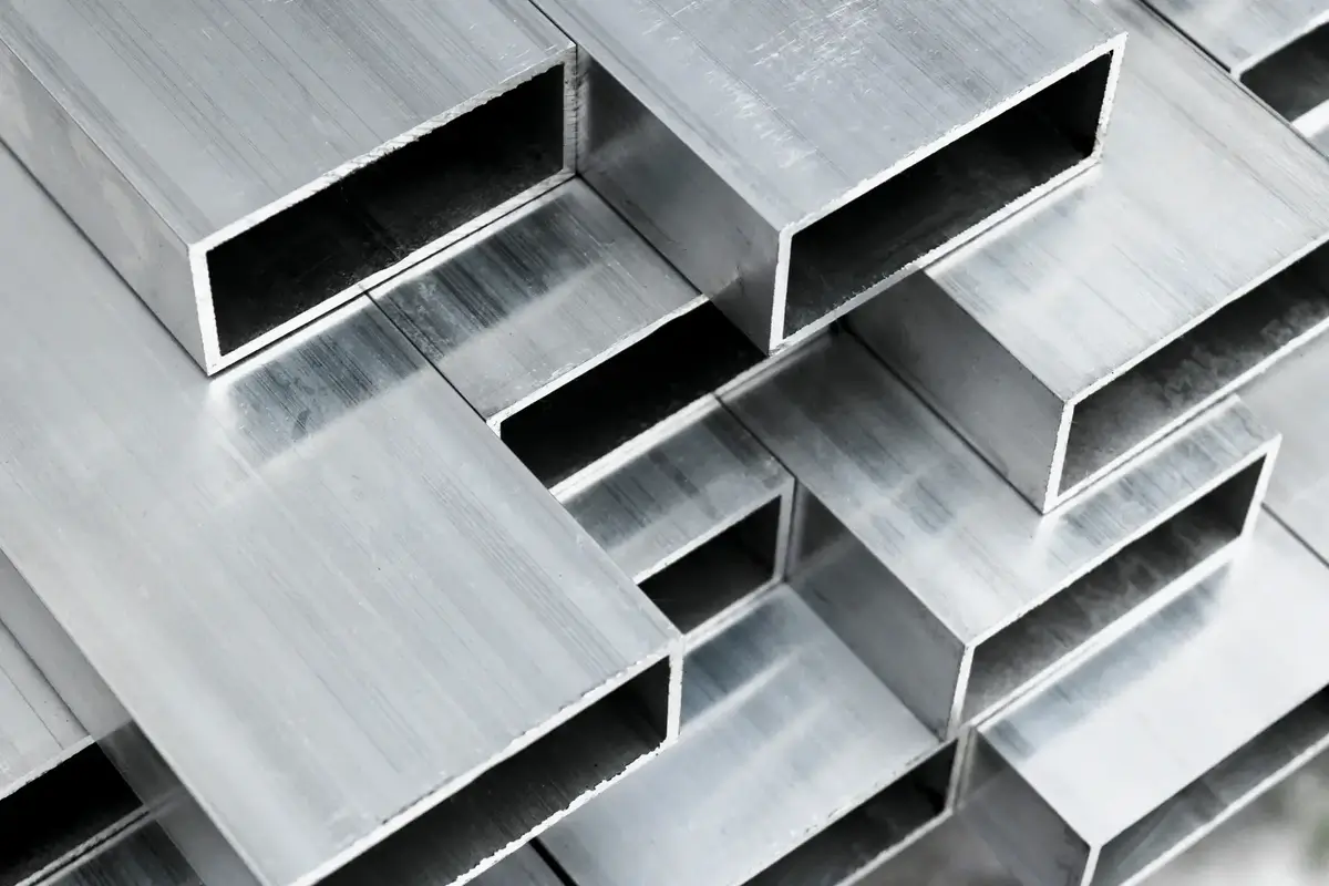 Stacked rectangular aluminum metal tubes with smooth brushed surfaces.