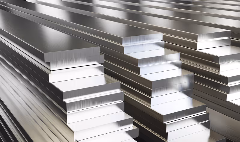 Stacks of polished aluminum bars with reflective surfaces arranged in rows.