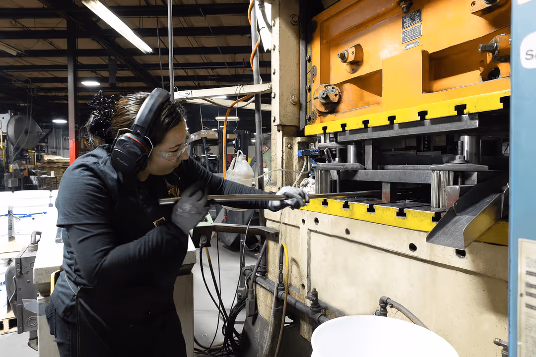 Mazak laser cutting machine producing sparks while cutting metal sheet with US Metal Crafters logo.