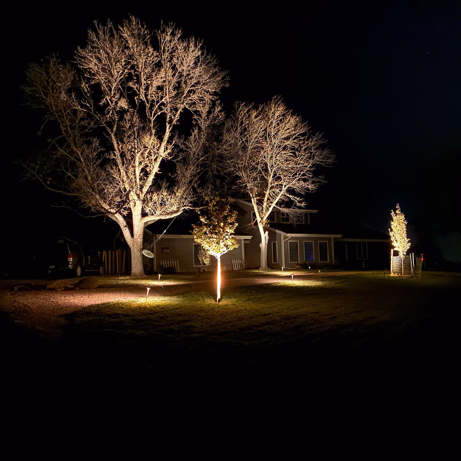 Landscape lighting installation illuminating a home at night