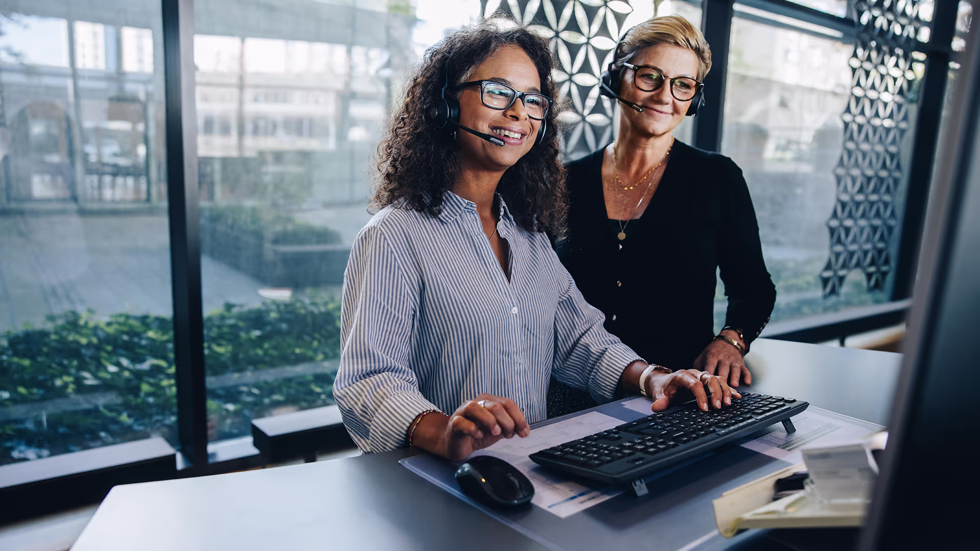 A woman working in call center with her supervisor.