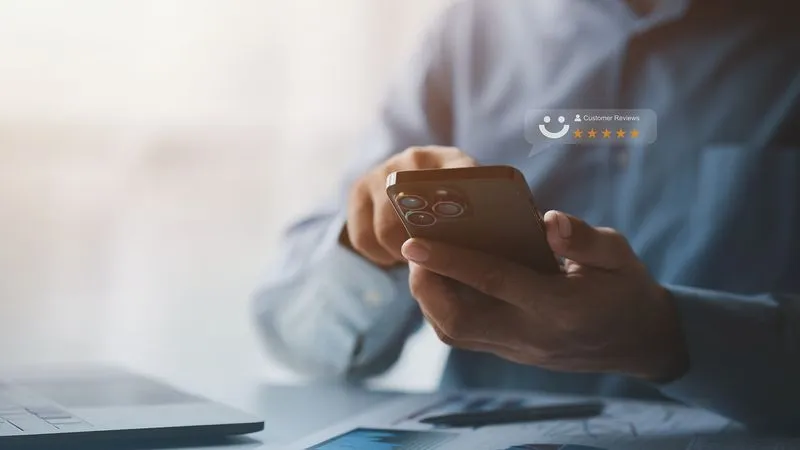 A man holding his phone checking reviews.