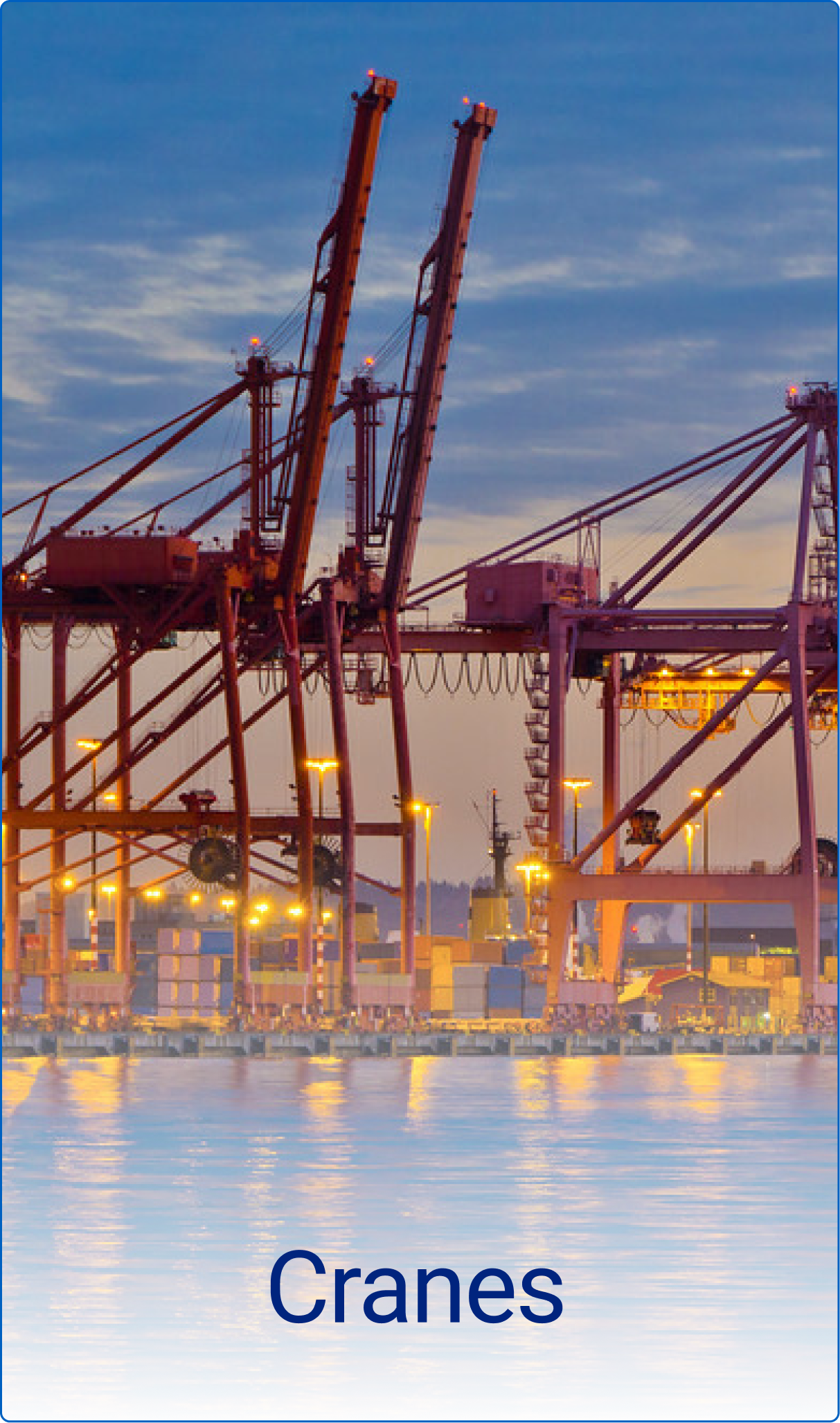 Large industrial cranes at a port with stacked shipping containers and water reflecting lights at dusk.