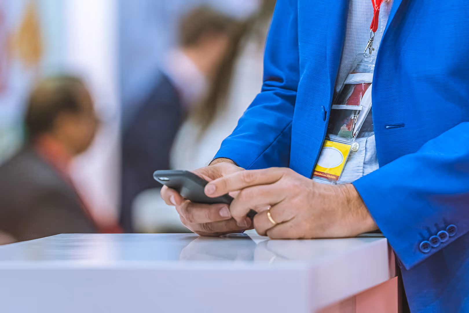 trade show exhibitor checking cell phone 