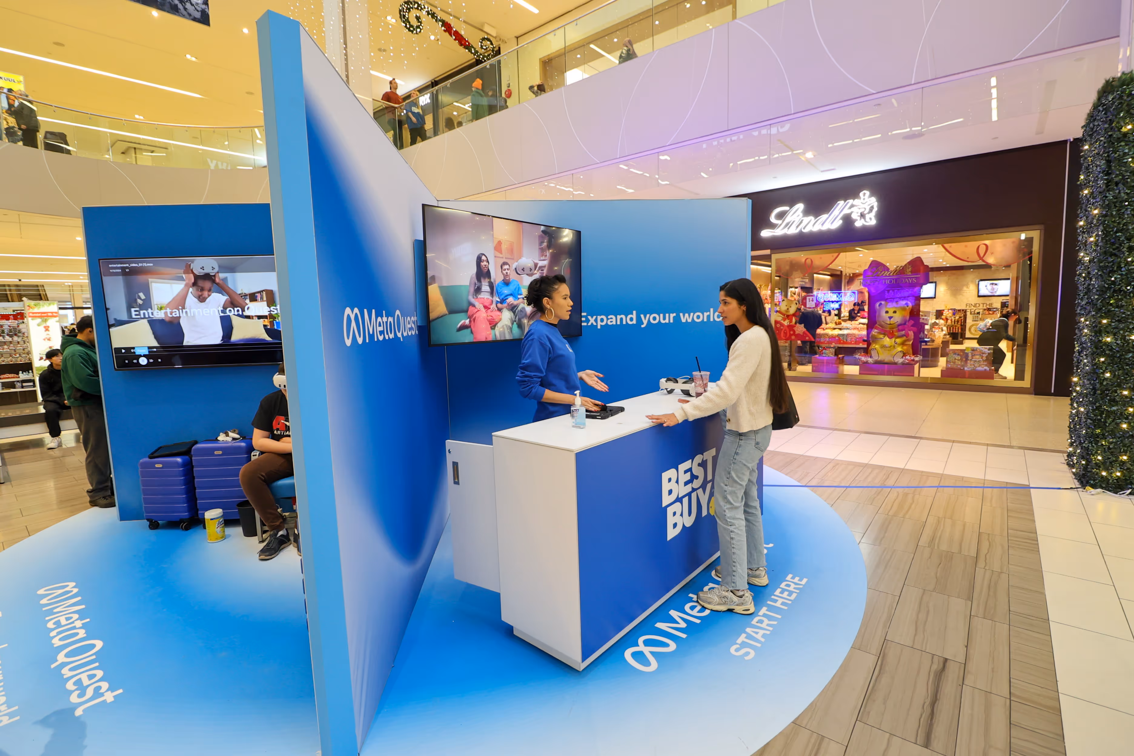 open-concept retail pop-up showing a segmented quadrant of an information desk and wall-mounted tv