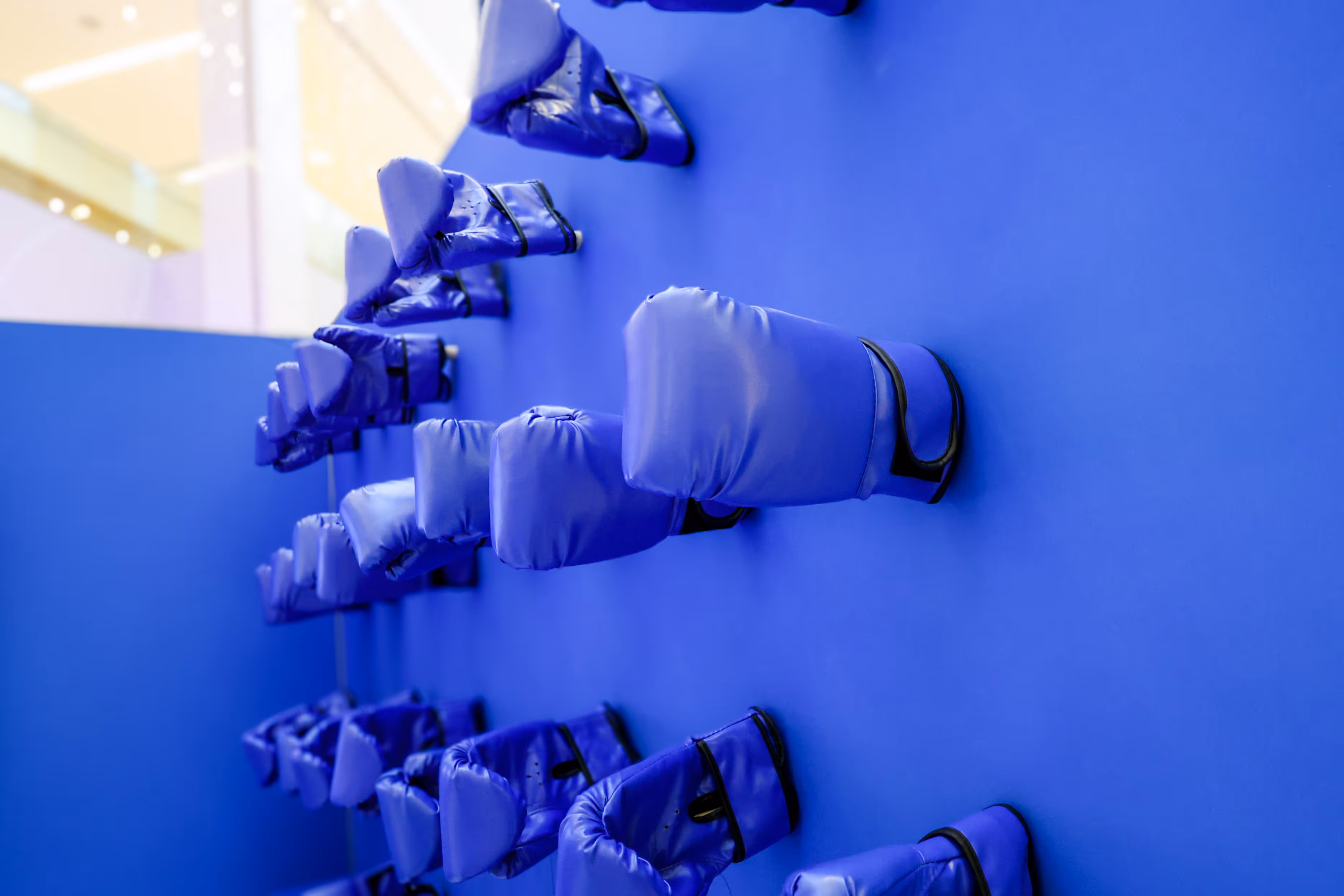 custom exhibit wall showing multiple rows of wall-mounted blue boxing gloves