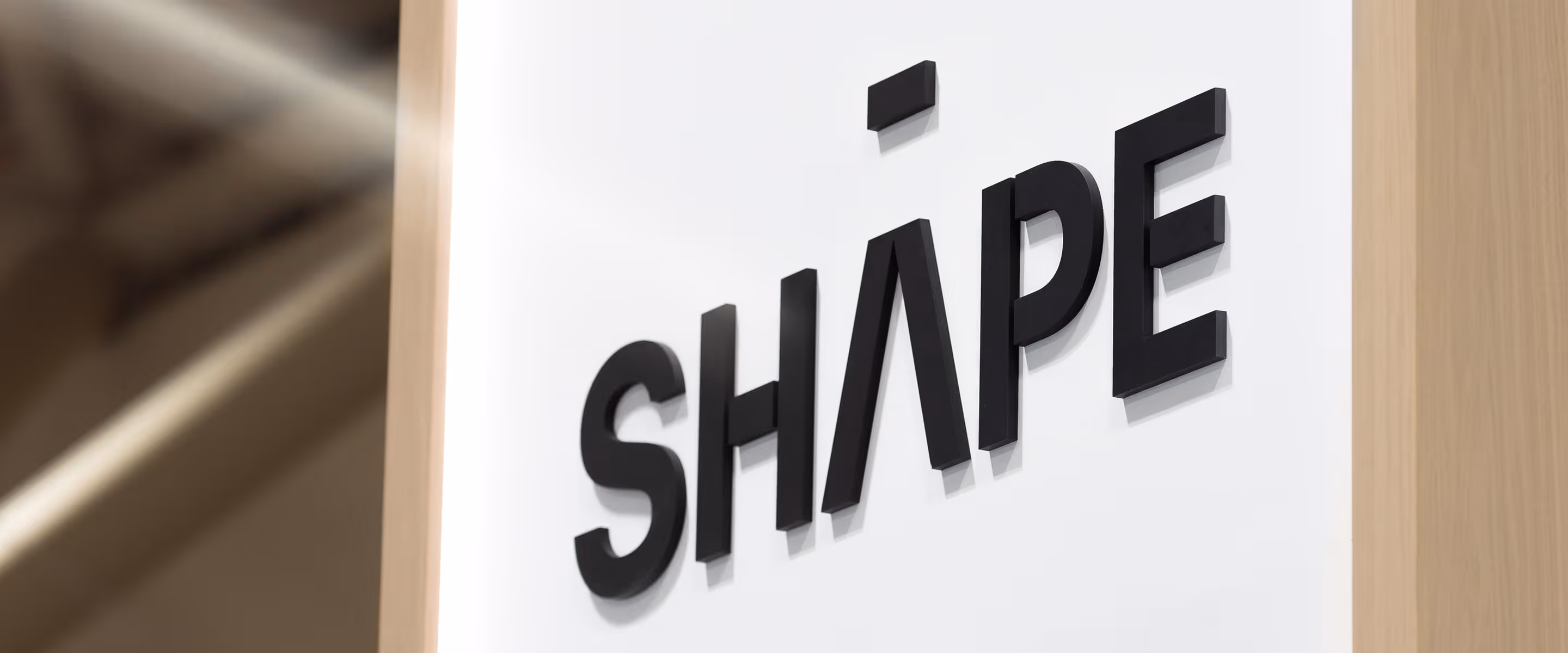 "shape" custom 3D letters mounted to a trade show exhibit column