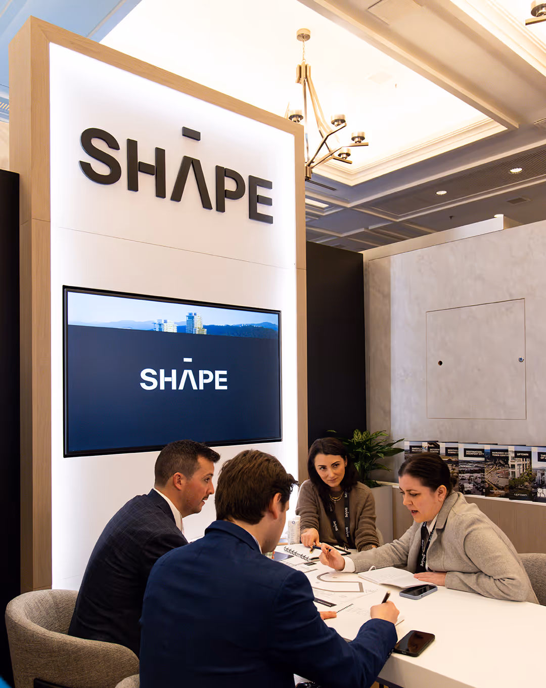 10x10 custom trade show booth with group of 4 meeting at the table