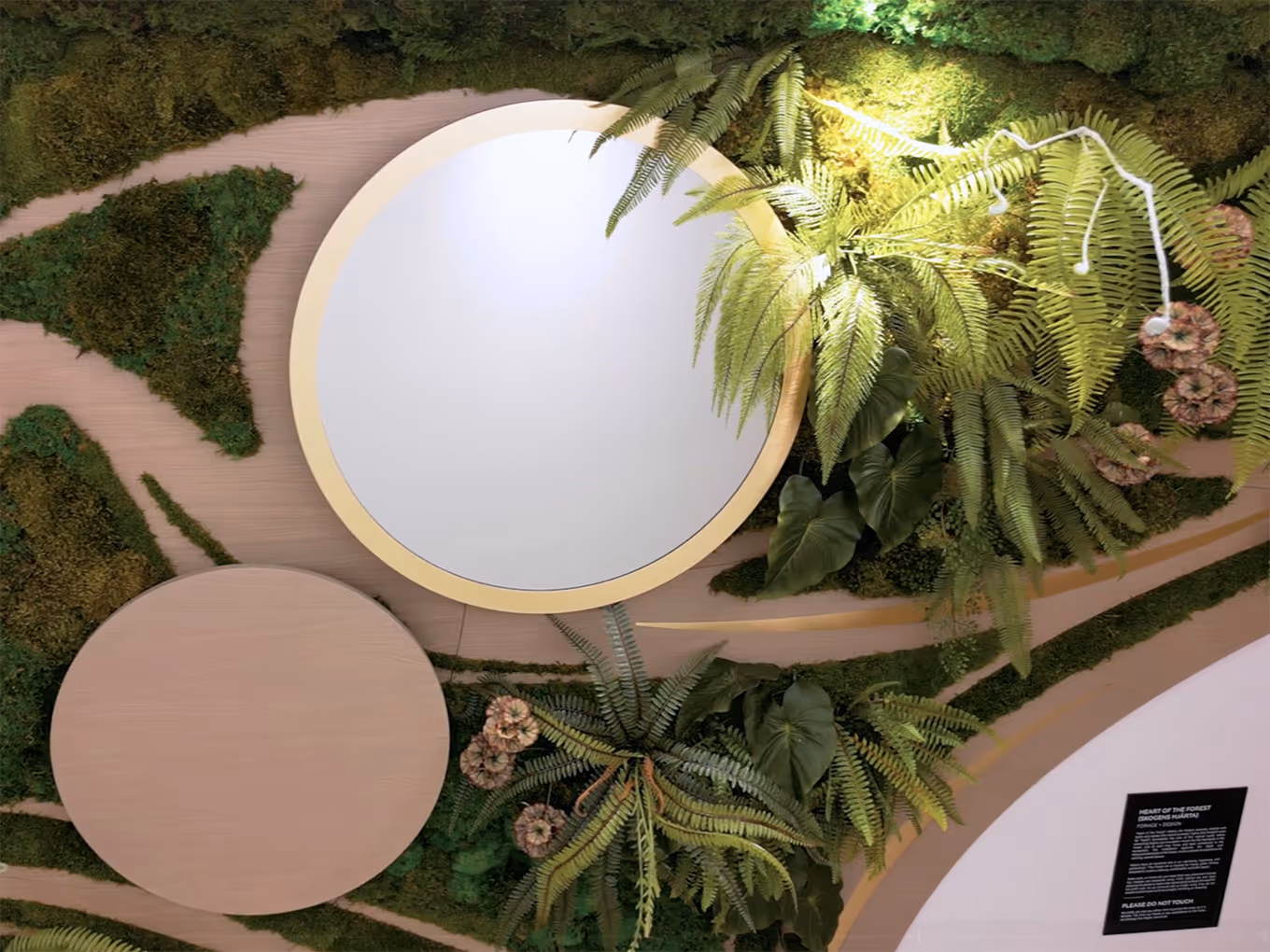 close up of a moss wall installation with mirrors and swirling millwork patterns