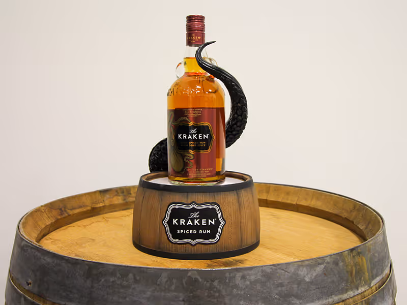 custom-made retail glass bottle display with a barrel-shaped, base and 3D printed tentacle wrapping around the bottle.