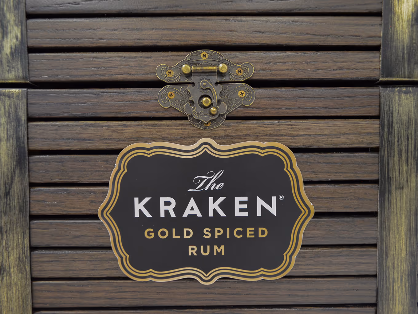 close up of a custom treasure chest display with a Kraken Rum plaque and brushed brass hardware.