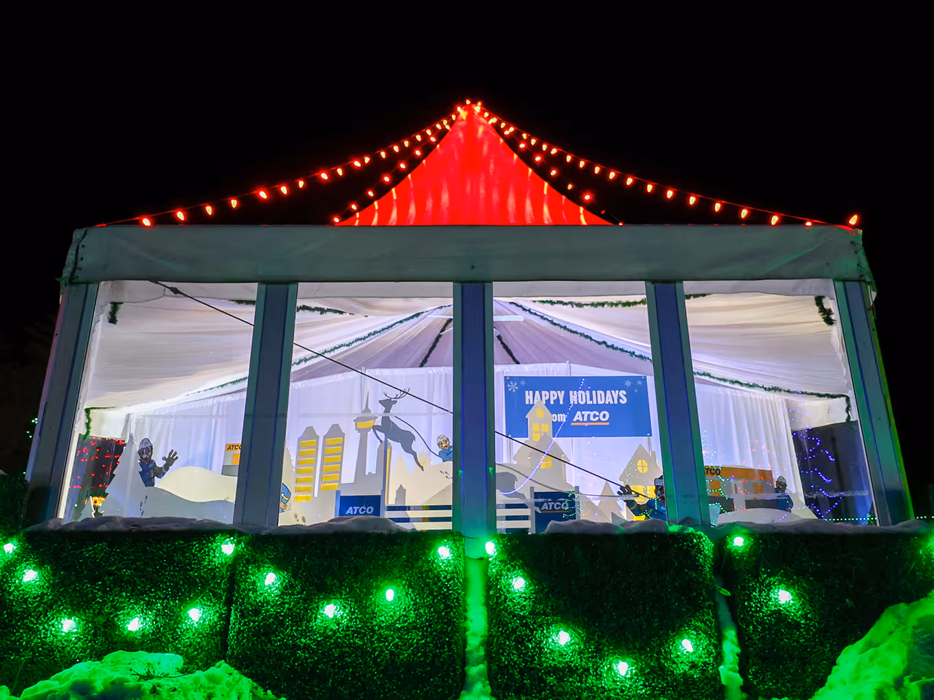 outside of an enclosed tent with windows that features a custom Christmas winter display in Calgary.