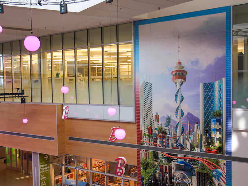 top half of a large-scale vinyl wall mural in an open lobby space. Custom-printed futuristic skyline of downtown Calgary shown.