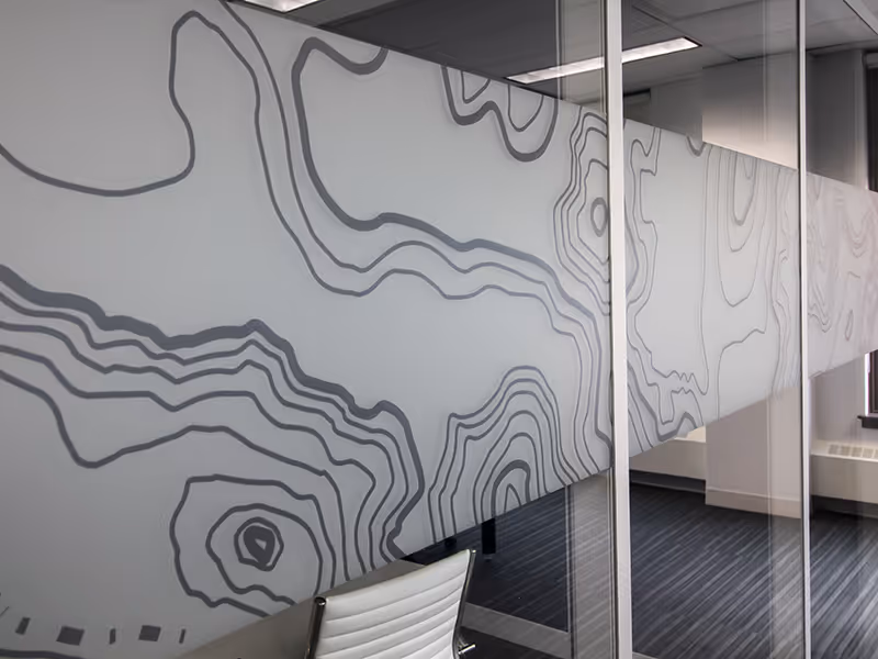 Close-up of silver topographic vinyl on glass, adding privacy while keeping the space airy.