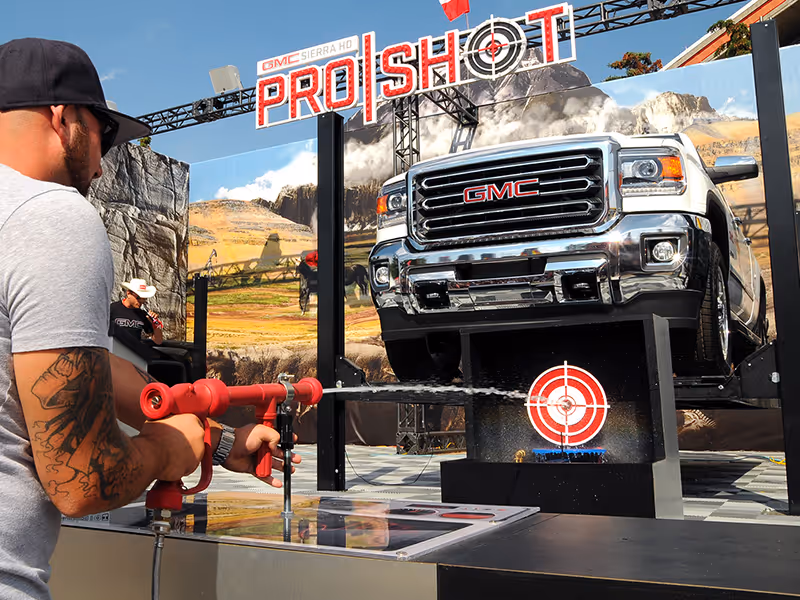 Guest uses a water gun to hit the ProShot target beneath a raised GMC Sierra HD during the Calgary Stampede activation.