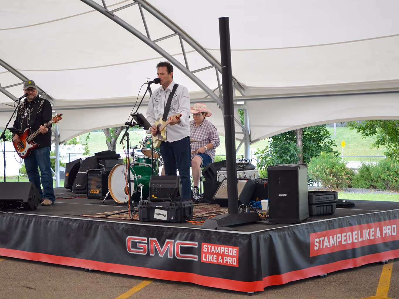 Live band plays on a GMC-branded stage at a Calgary Stampede dealership pop-up.