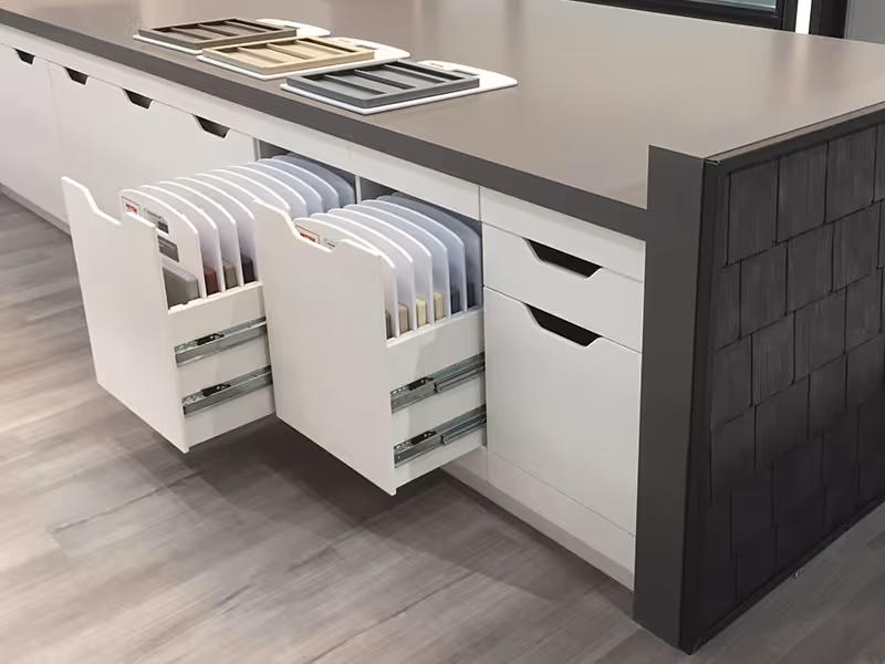 Island counter with open sample drawers displaying organized siding and trim boards for hands-on product selection.
