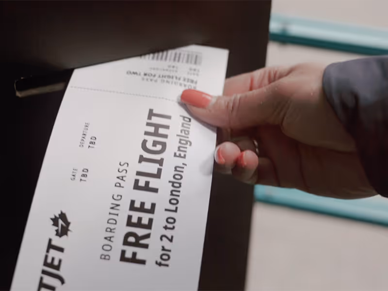 Authentic teal K6 phone booth ringing on a Calgary street corner, inviting pedestrians to participate in WestJet’s surprise giveaway.