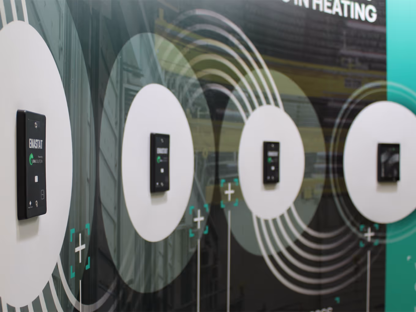 Close-up view of ENA Solutions smart thermostats mounted flush into CNC-cut aluminum backing behind a printed pop-up display for hands-on product demonstrations.