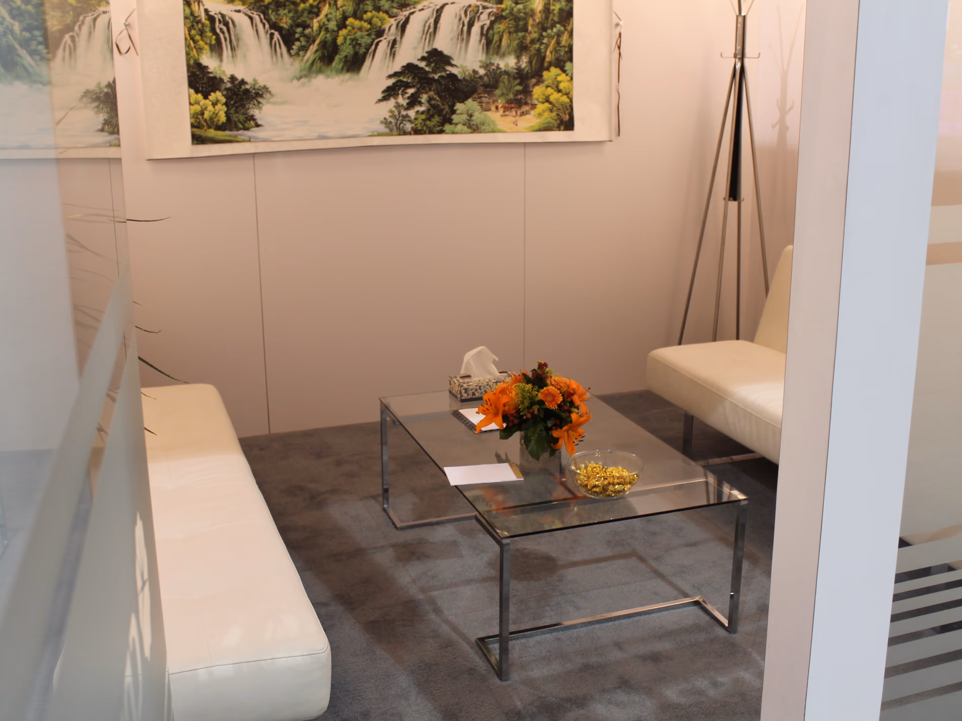 Close-up of the CPTDC trade show meeting room interior with frosted glass panels, modern seating, floral décor, and framed landscape artwork.
