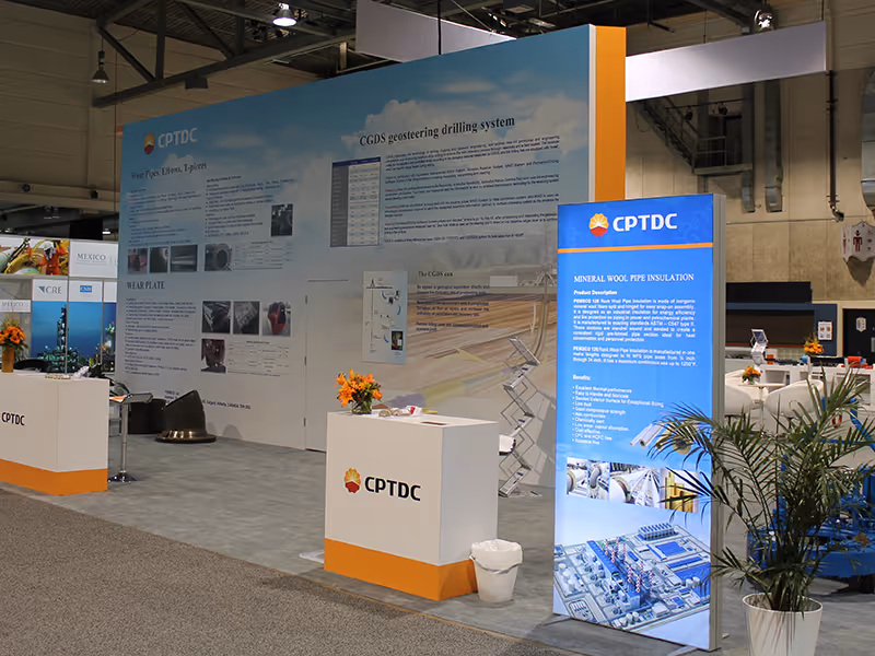 Side view of the CPTDC custom exhibit showing educational wall graphics, branded counters,, product information displays, and freestanding backlit towers.