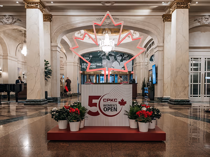 Photo-ready CPKC Women’s Open display featuring glowing maple leaf silhouette and branded base, installed as an eye-catching lobby centerpiece for guest engagement.