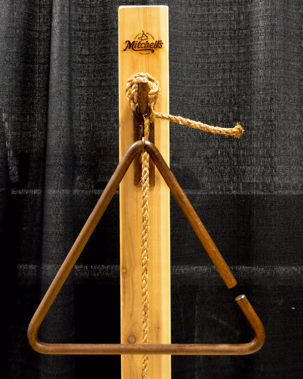 Custom-built cedar dinner bell with iron triangle and wood-burned Mitchell’s logo, fabricated for the Mitchell’s Bacon Battle cook-off event.