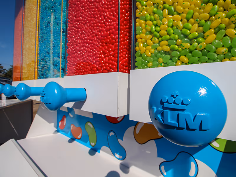 Detailed shot of the KLM custom jellybean dispenser bins filled with brightly coloured candy and branded dispensing knobs.