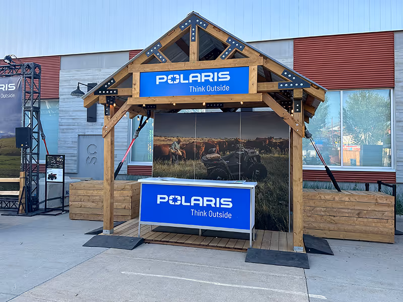 Close-up of the Polaris blue kiosk featuring integrated signage, promotional graphics, and display screens at the Calgary Stampede.