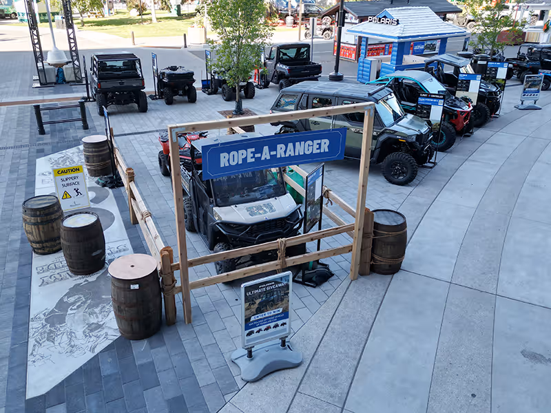 Overhead view of the Polaris Rope-A-Ranger activation zone surrounded by off-road vehicles and interactive signage at the Calgary Stampede.