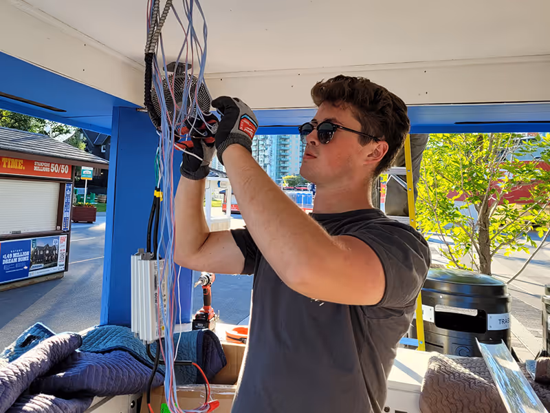 Exhibit Studio team member wiring and assembling electrical components inside the refurbished Polaris Stampede kiosk during fabrication.