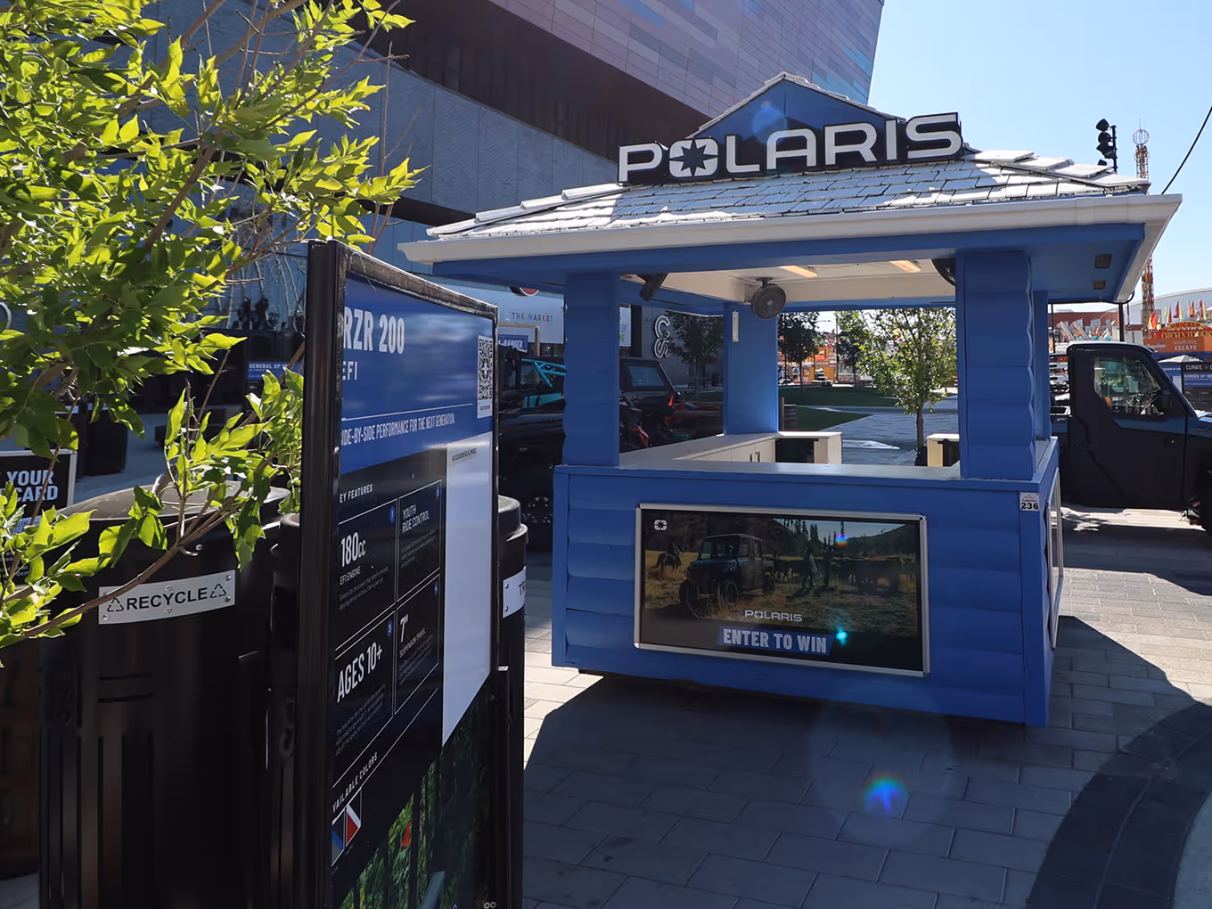 Polaris branded wooden exhibit booth with custom structural framing, roof beams, and a large vinyl backdrop featuring off-road vehicle graphics.