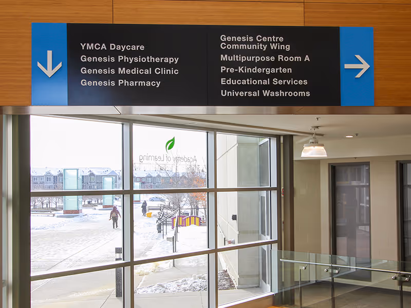 custom-built directional sign inside a community rec centre with dimensional letters and arrows