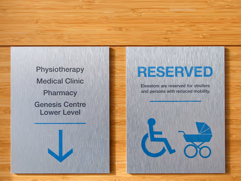 elevator lobby custom brushed aluminum sign with blue titles, symbols, and arrows