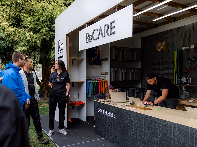 Covered outdoor reCare Arc’teryx booth with a service desk for garment repairs.