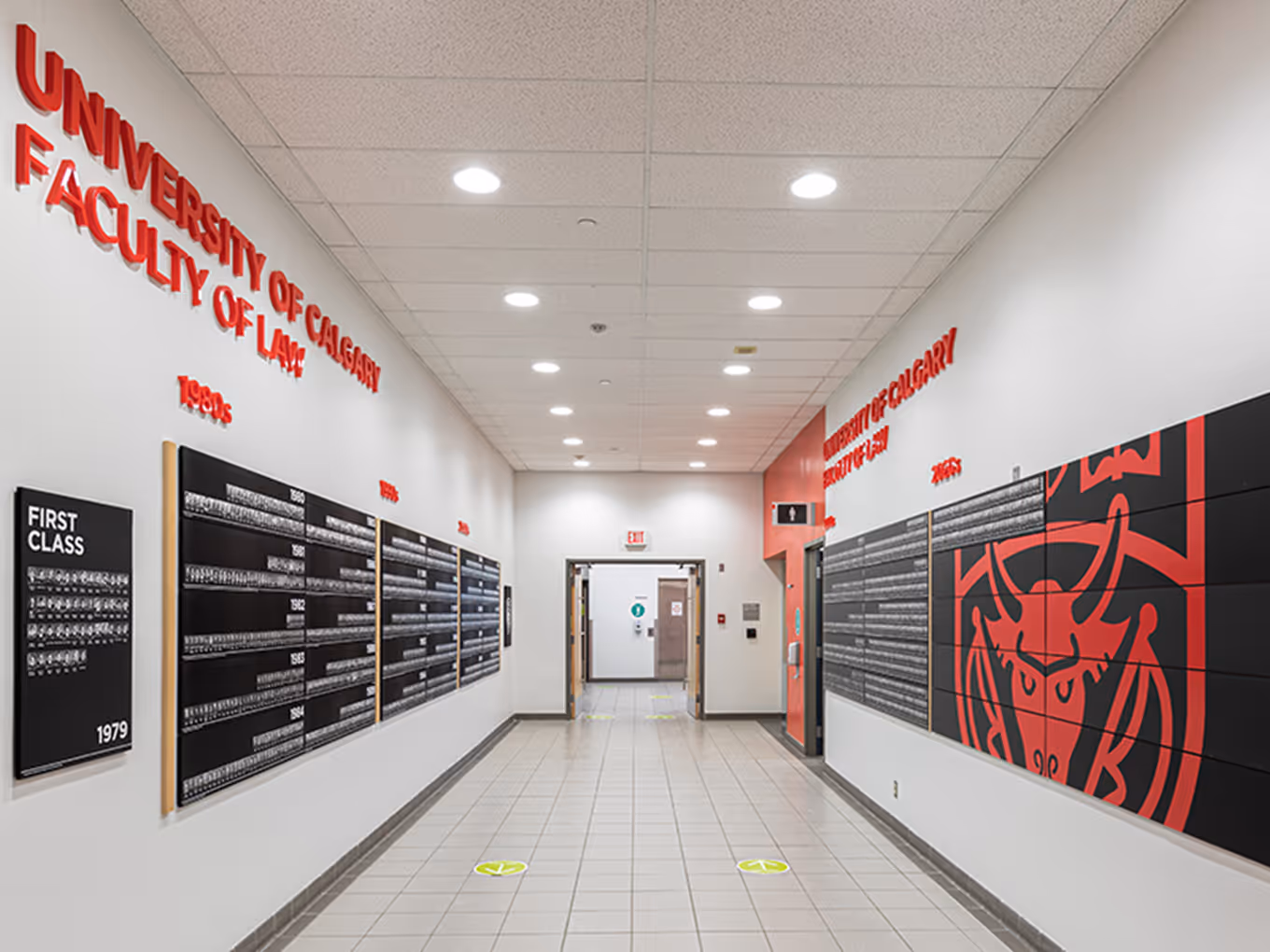 Graduation recognition wall at the University of Calgary Faculty of Law displaying graduate portraits organized by year.