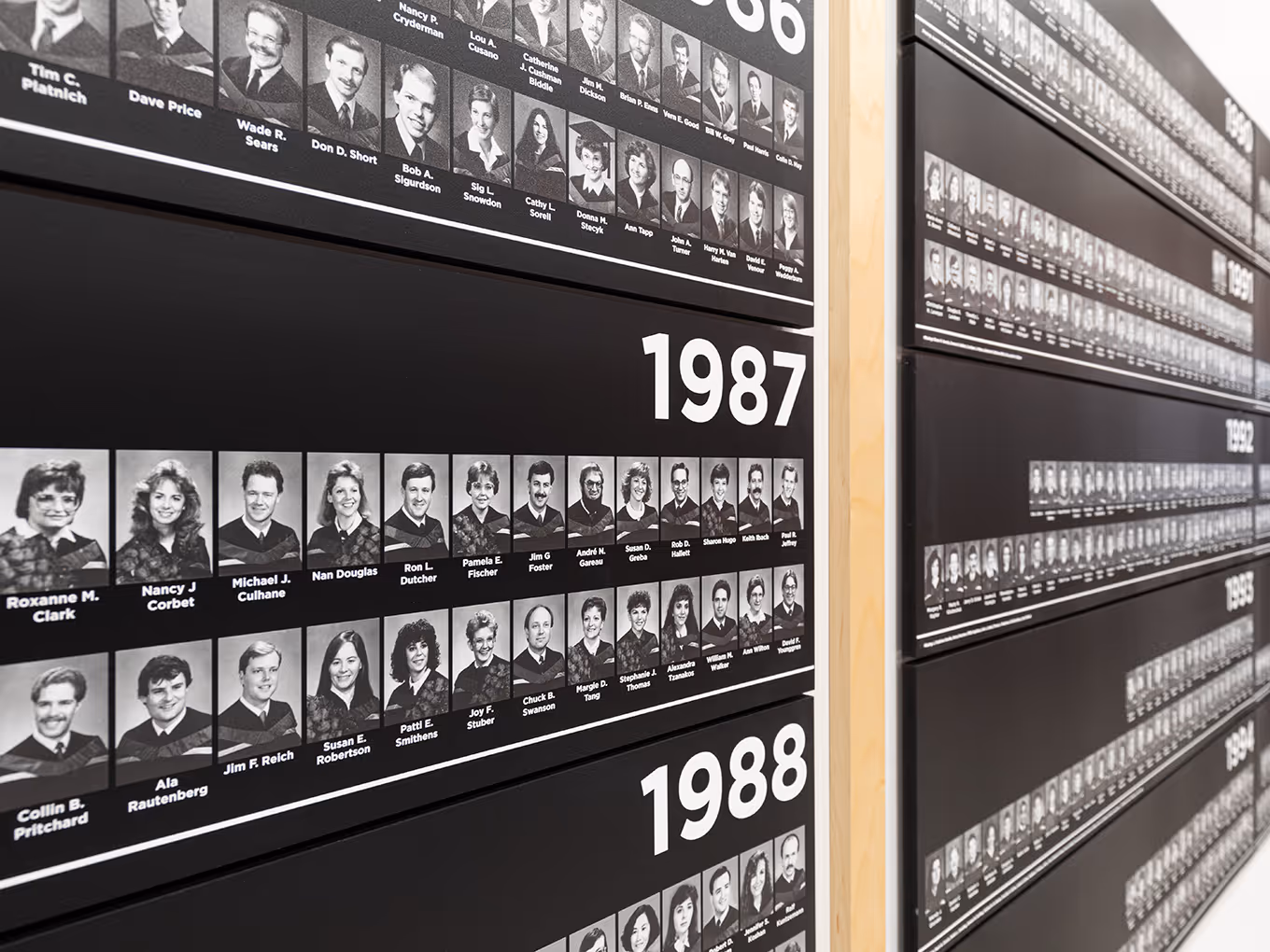 Close-up of University of Calgary Faculty of Law graduation panels showing individual graduate portraits and year labels.